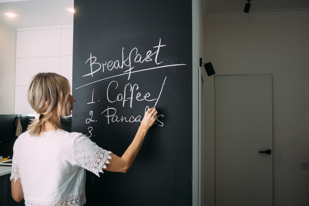 femme qui écrit sur un tableau à craie